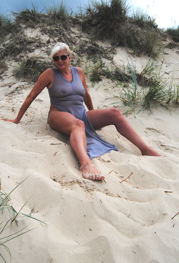 19P Die schöne vollbusige reife Dimonty posiert vollständig bekleidet in einem hauchdünnen Kleid am Strand