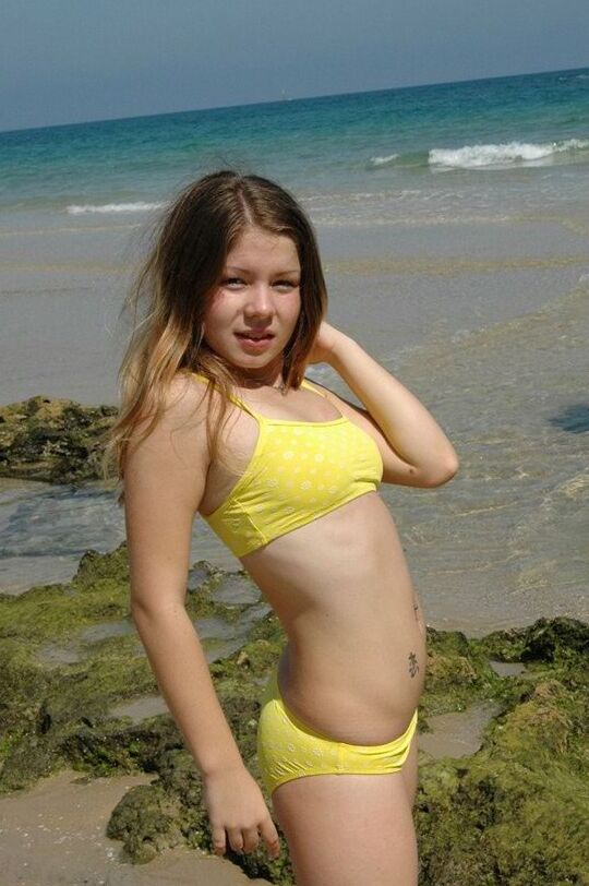 15P Emily posing at the beach in a yellow bikini