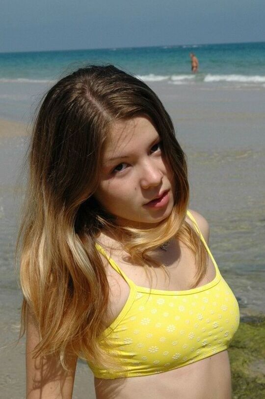 15P Emily posing at the beach in a yellow bikini