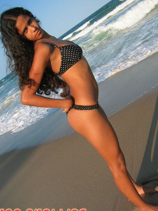 16P La amateur brasileña Polliana modela en bikini en una playa de arena