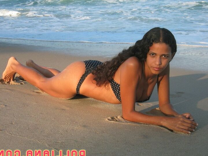 16P La amateur brasileña Polliana modela en bikini en una playa de arena