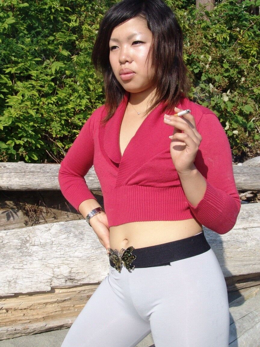 16P Asian amateur Sugar slips spandex pants over her ass while smoking on a beach