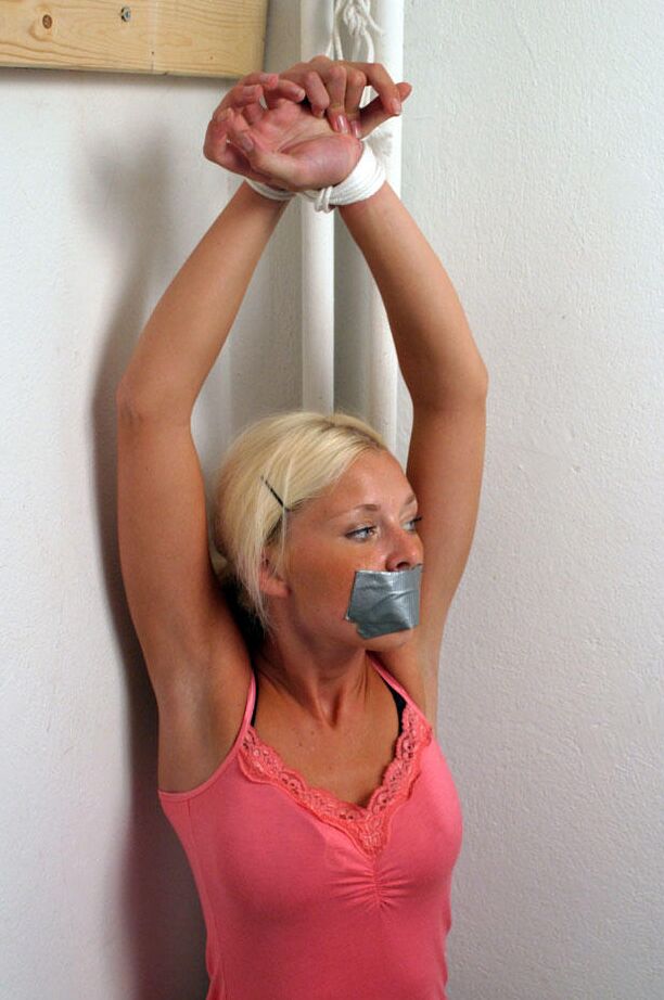 12P Clothed blonde is shut up with duct over mouth and wrists tied together