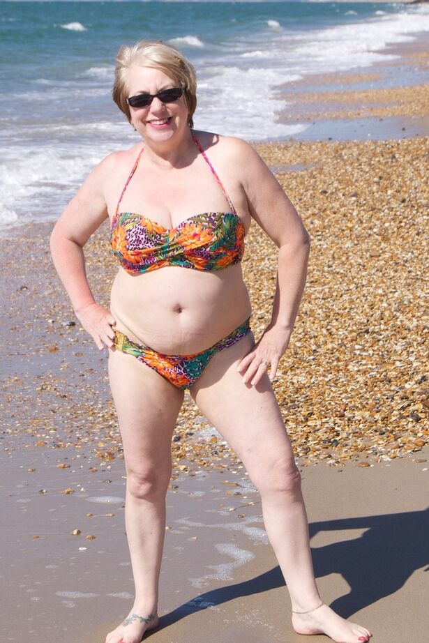 20P Mature UK woman Speedy Bee wears sunglasses while getting naked at the beach