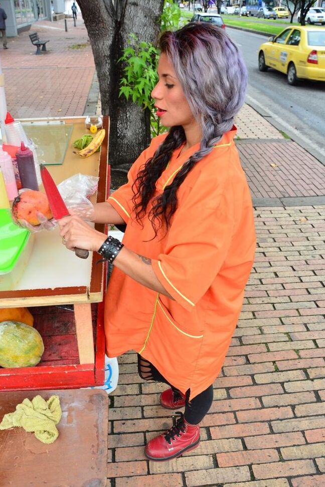 17P Beautiful Colombian fruit seller gestures provocatively with a banana
