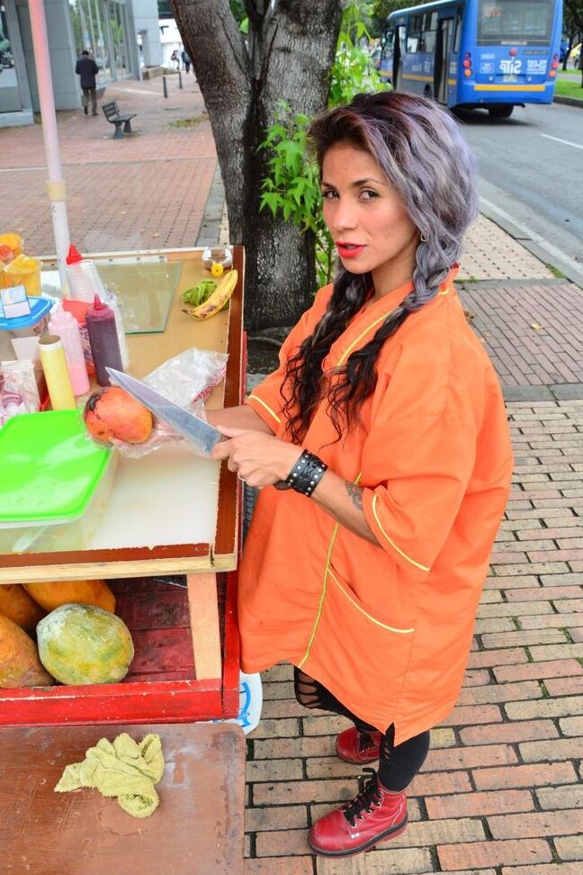 17P Beautiful Colombian fruit seller gestures provocatively with a banana