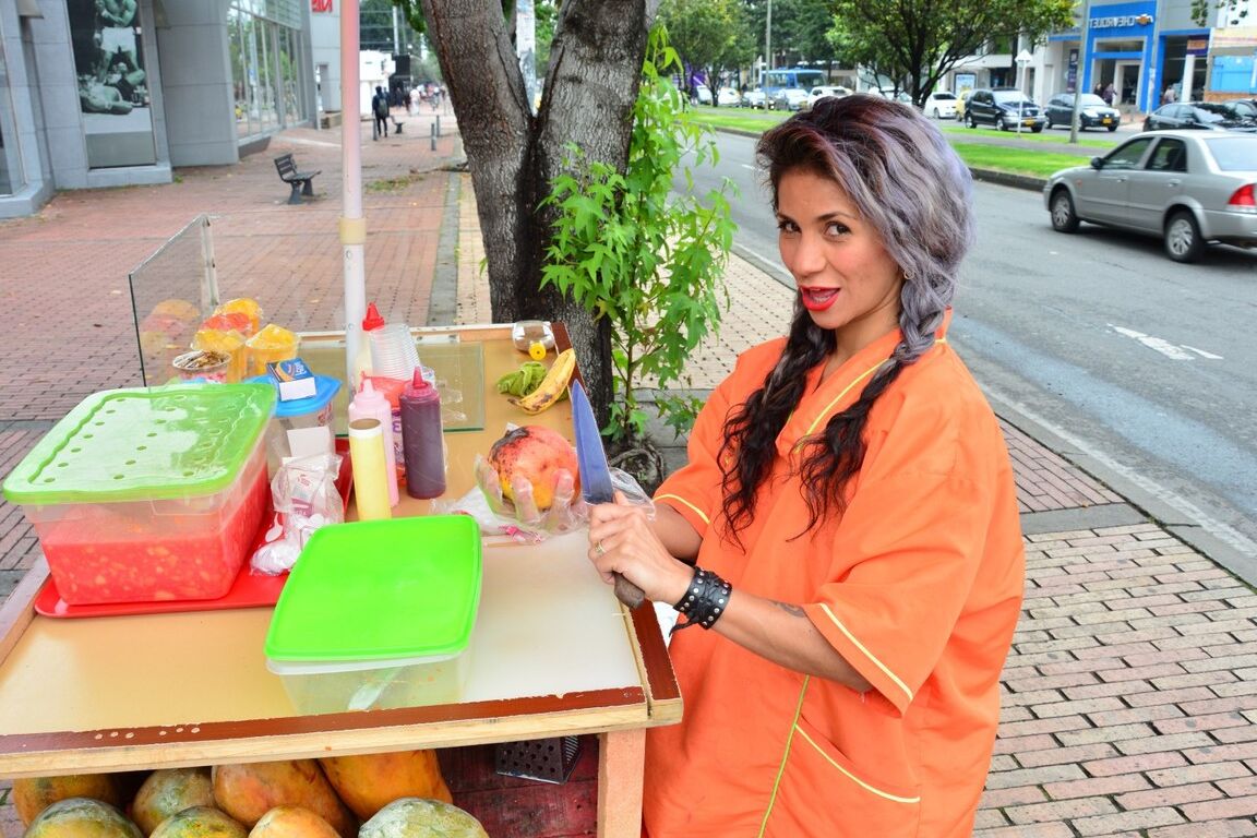 17P Beautiful Colombian fruit seller gestures provocatively with a banana