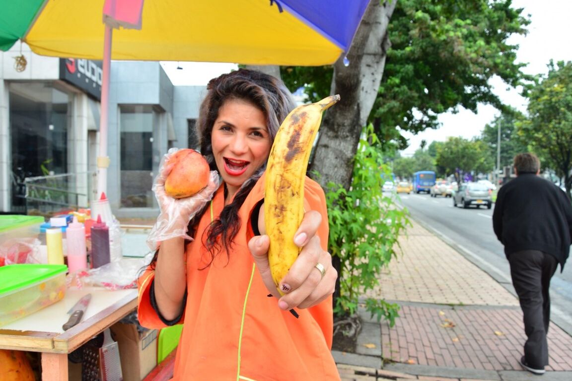 17P Beautiful Colombian fruit seller gestures provocatively with a banana