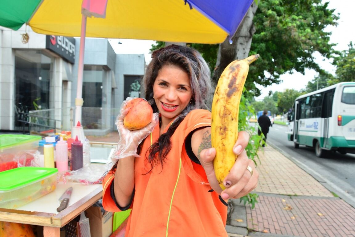 17P Beautiful Colombian fruit seller gestures provocatively with a banana