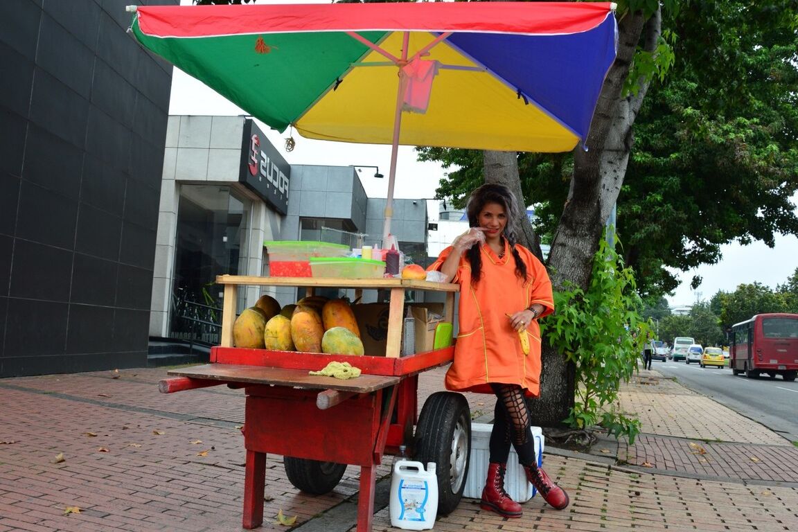17P Beautiful Colombian fruit seller gestures provocatively with a banana