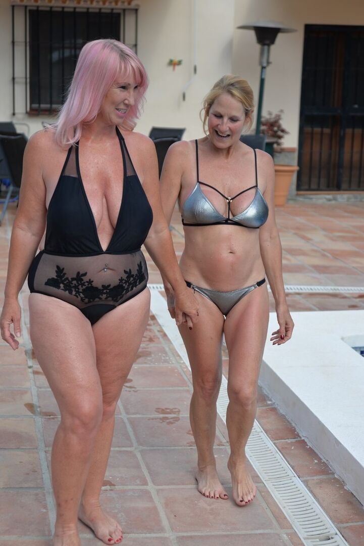 20P BBW madura Melody e sua namorada caminham de mãos dadas à beira da piscina em trajes de banho