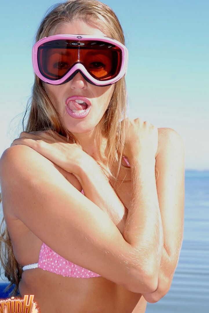 15P Lori Anderson licks her lips on a watercraft in a bikini and goggles