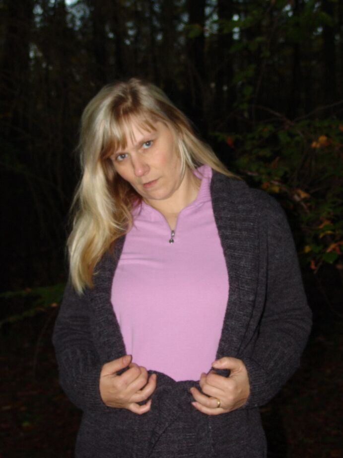 20P La blonde mature Sweet Susi montre son cul nu près d'une pile de bois de chauffage
