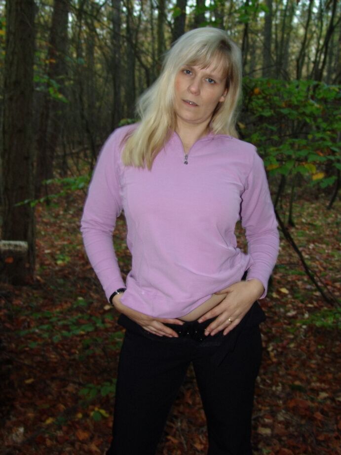 20P La blonde mature Sweet Susi montre son cul nu près d'une pile de bois de chauffage