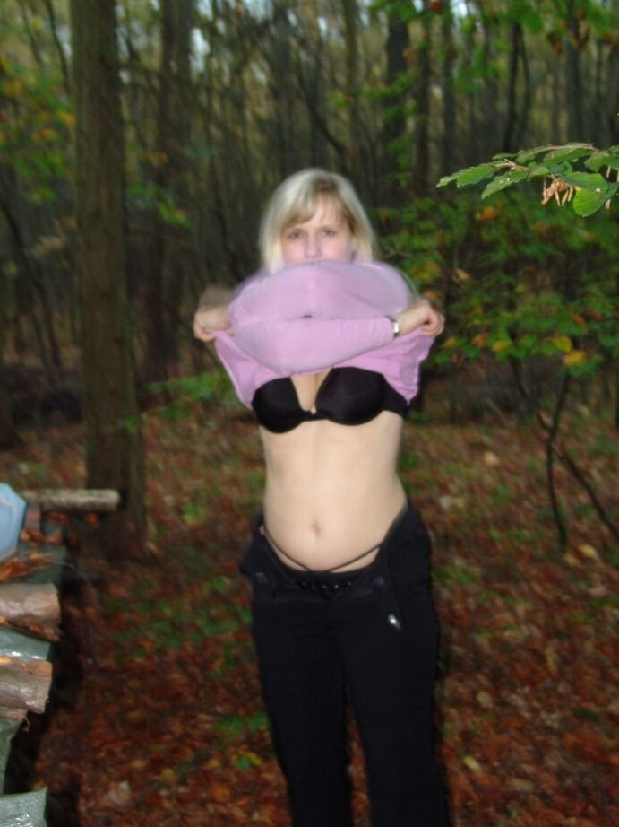 20P La blonde mature Sweet Susi montre son cul nu près d'une pile de bois de chauffage