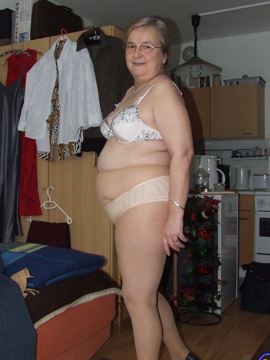 21P A vovó europeia gorda Sybille tirando as roupas e as meias de tom de pele