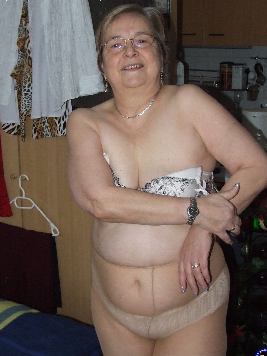 21P A vovó europeia gorda Sybille tirando as roupas e as meias de tom de pele