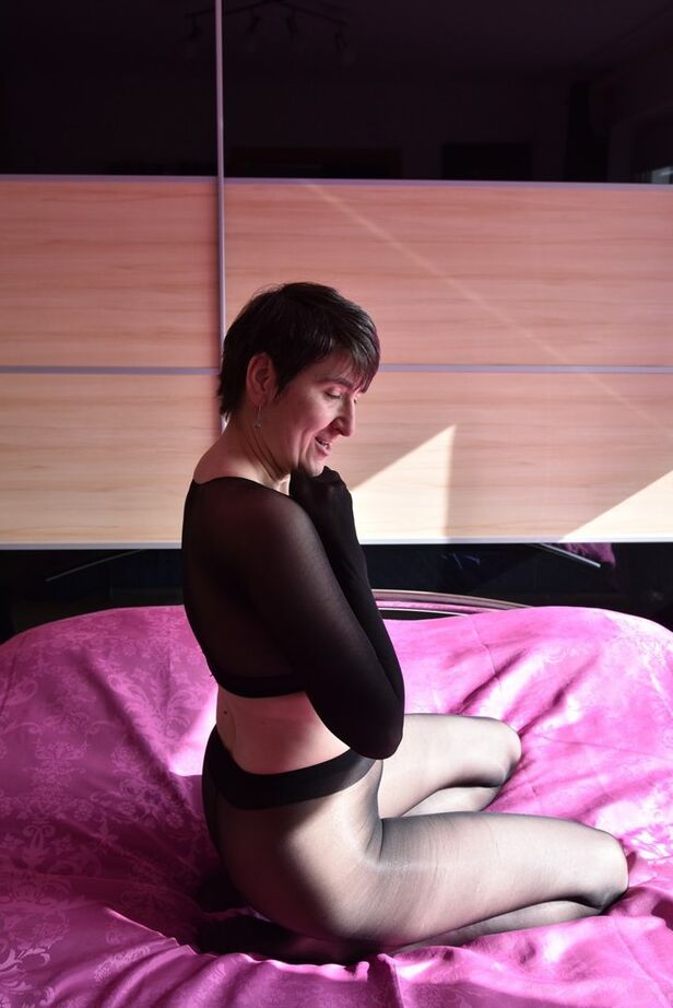 20P Modelo amador Hot MILF mostra os peitos em uma cama com meia-calça preta