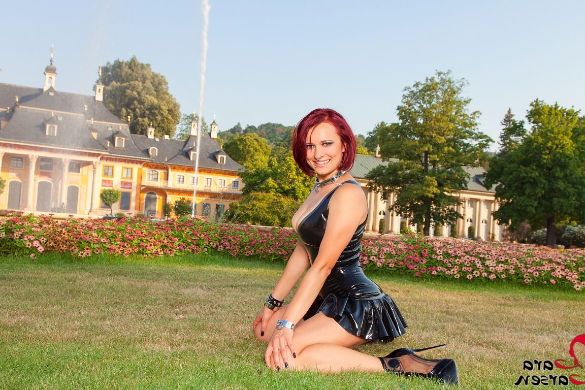 12P A ruiva amadora Lara Larsen modela um vestido de látex e botas de salto agulha em um quintal