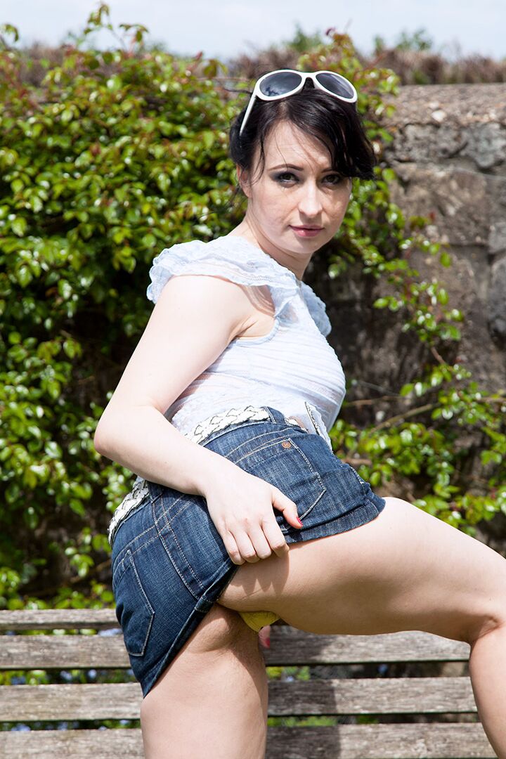 16P La amateur de pelo oscuro Jena muestra sus bragas bajo la falda abriendo las piernas al aire libre