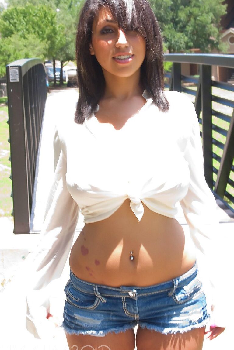 16P Hottie Shami Halil con pantalones cortos y camiseta blanca posando bajo el sol