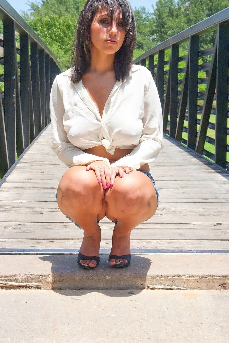 16P Hottie Shami Halil con pantalones cortos y camiseta blanca posando bajo el sol