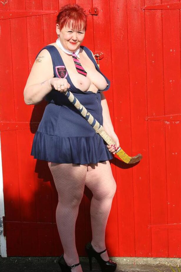 20P Mature redheaded wields a field hockey stick while exposing herself outdoors
