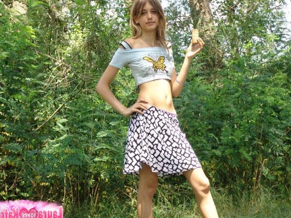 10P Shapely young teen in tiny t-shirt and short skirt posing outdoors