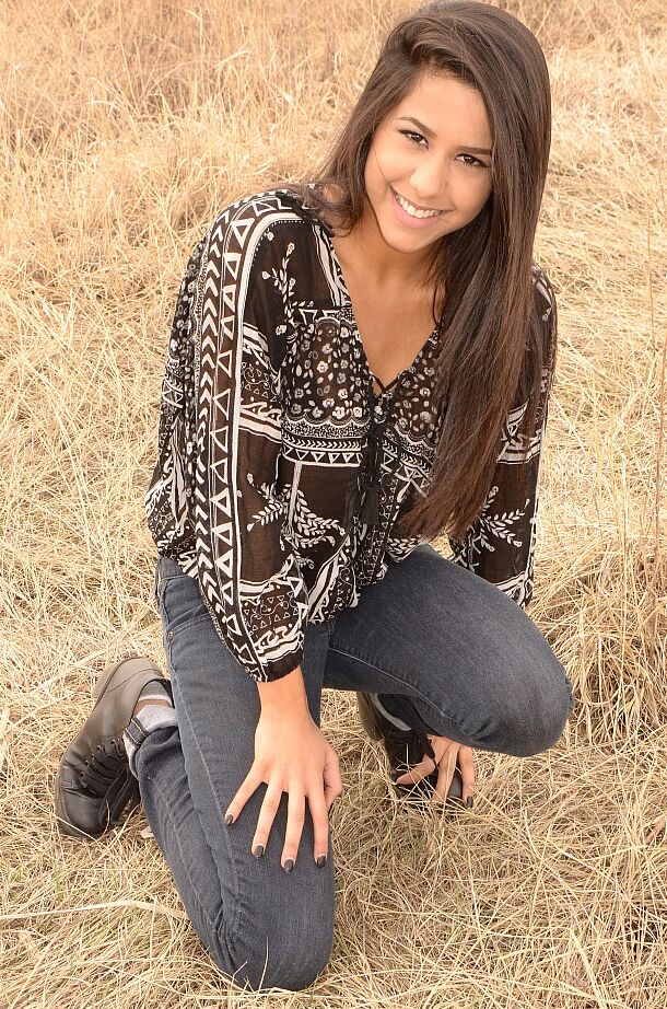 12P A garota latina Bella Quinn modela em um campo usando sutiã e jeans