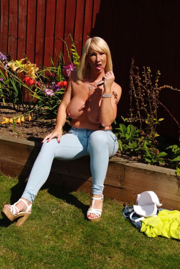 20P Melody, blonde aux gros seins, se prélasse seins nus dans la cour et exhibe ses seins matures et chauds.