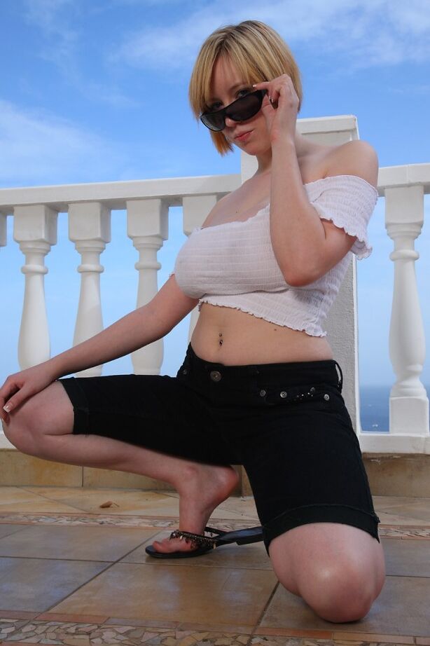 21P Busty MILF in sunglasses Jenny Jones toys her shaved clam on a balcony