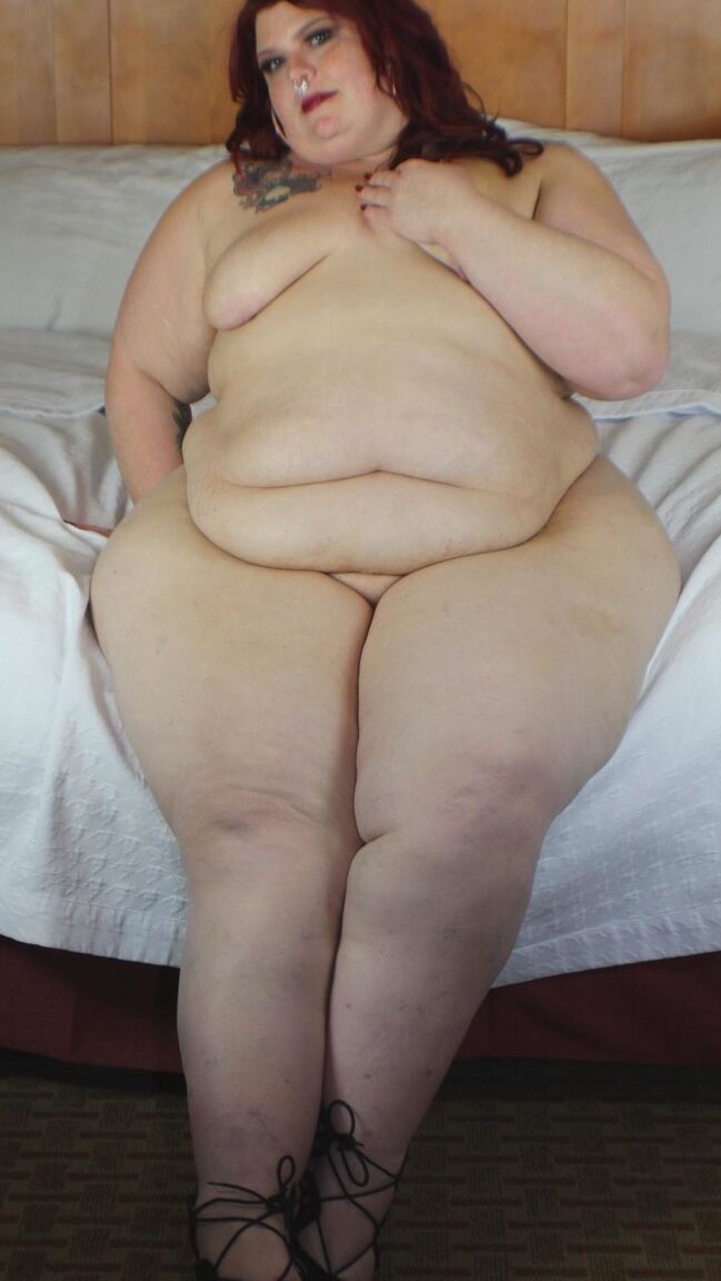 12P Redhead SSBBW Nikki Cakes shows her massive ass while face down on a bed