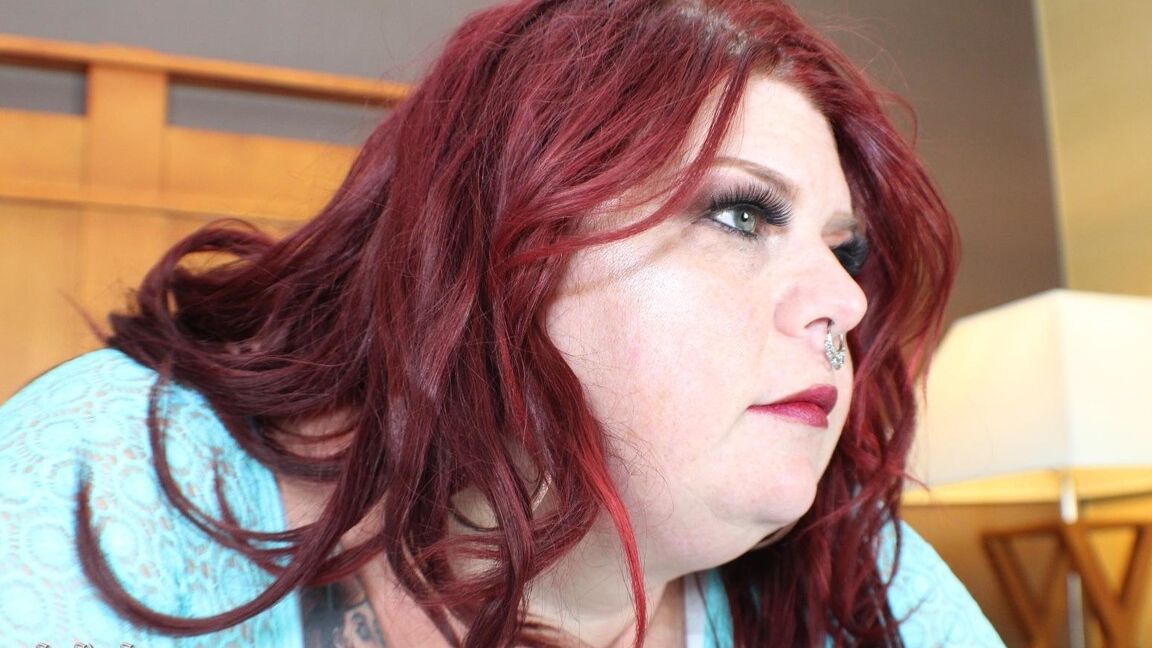 12P Redhead SSBBW Nikki Cakes shows her massive ass while face down on a bed