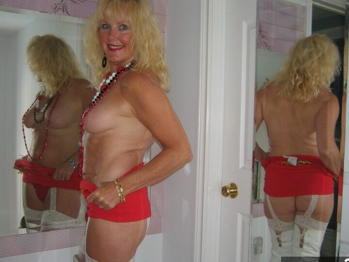 20P Aged blonde amateur Ruth goes topless in a mirror while wearing stripper boots