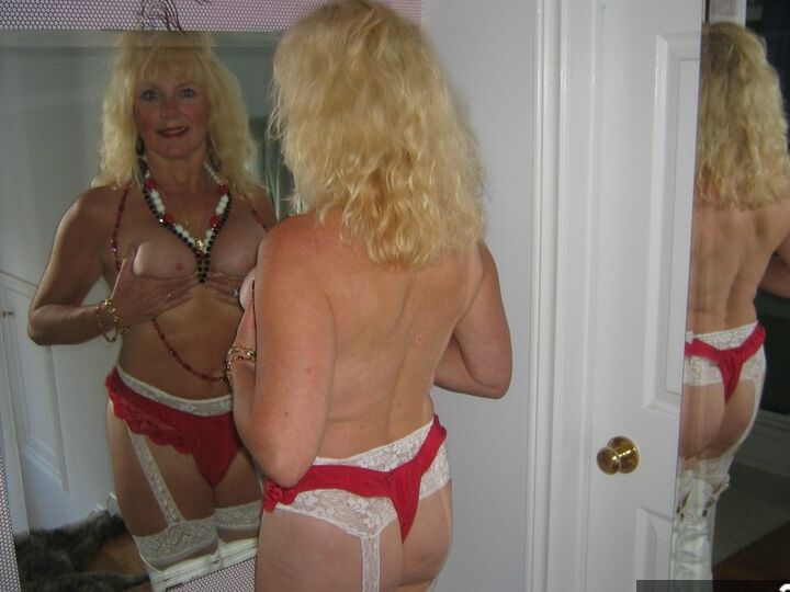 20P Aged blonde amateur Ruth goes topless in a mirror while wearing stripper boots