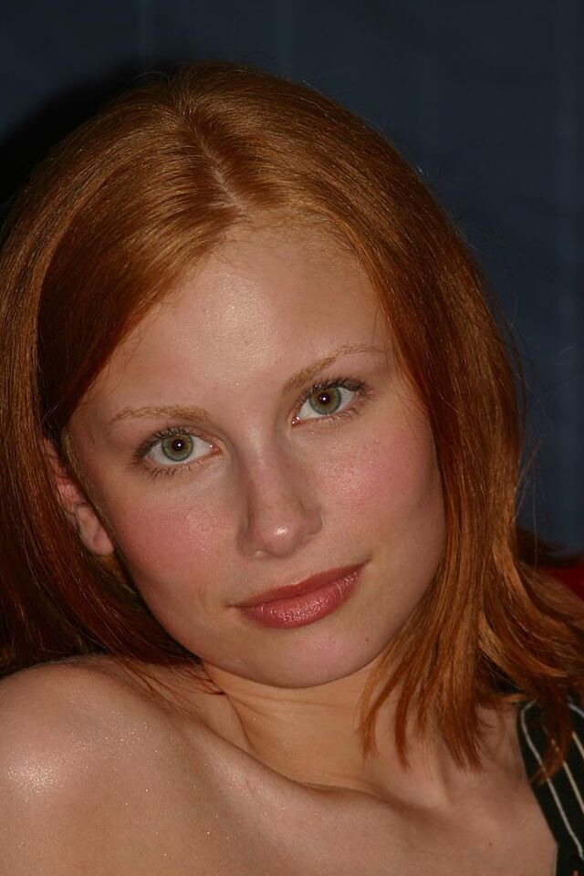 16P Anya, la rousse naturelle, enlève son string rouge pour se poser nue sur un canapé rouge
