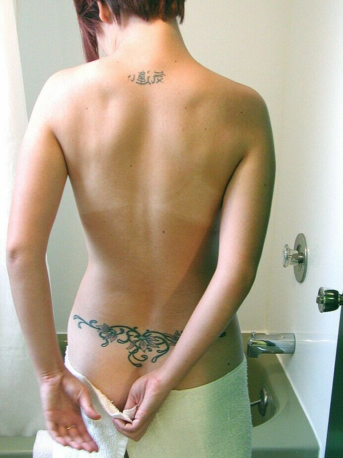 Gwen, mannequin asiatique amateur, expose ses sirènes et ses tatouages ​​dans la salle de bain.
