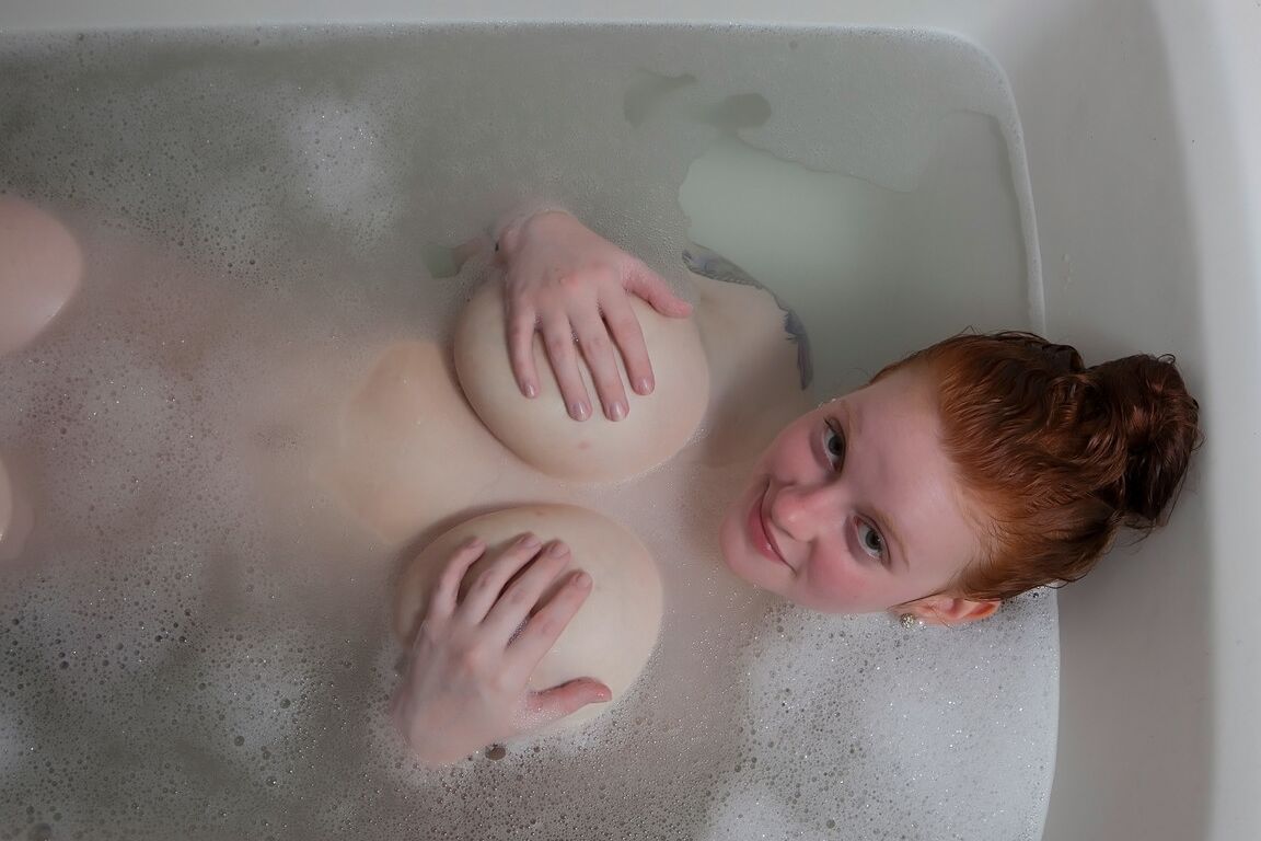 16P Pale redhead Kaycee Barnes displays her large boobs and butt during a bath