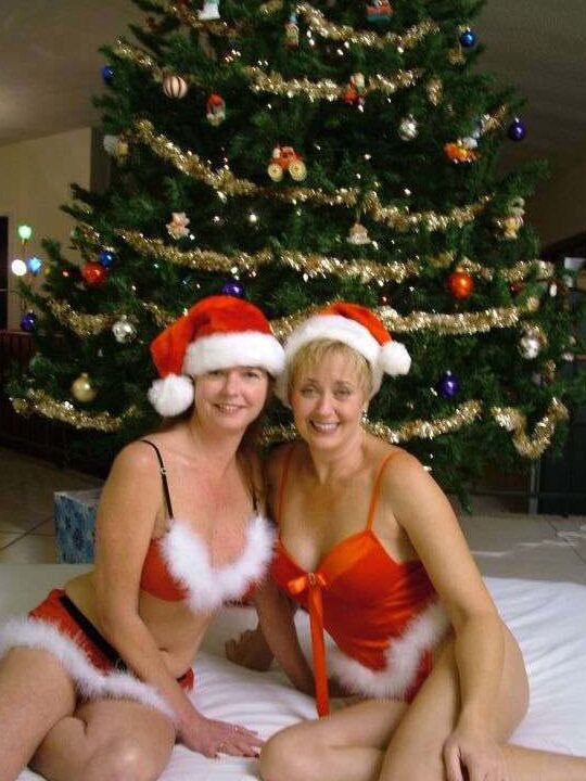 21P Amateur swingers in Xmas caps toy each other in front of a Christmas tree