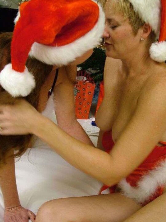 21P Amateur swingers in Xmas caps toy each other in front of a Christmas tree
