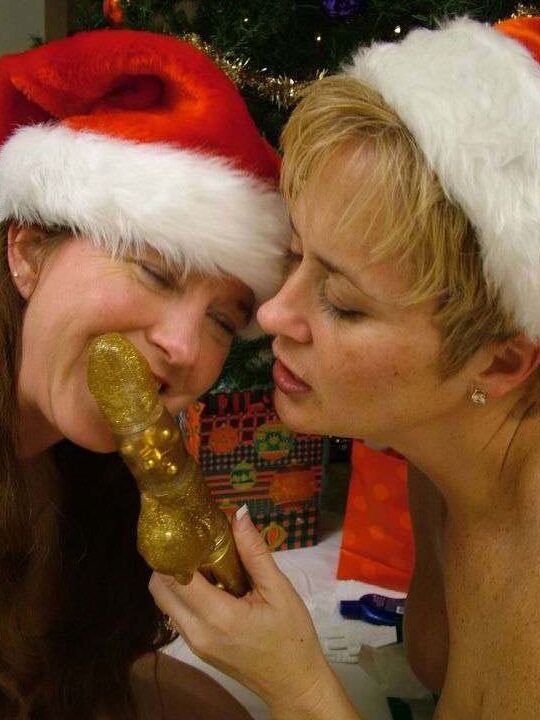 21P Amateur swingers in Xmas caps toy each other in front of a Christmas tree