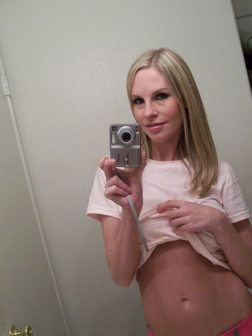 Die 15P blonde Amateurin Aimee enthüllt ihre falschen Brüste, während sie Spiegel-Selfies macht