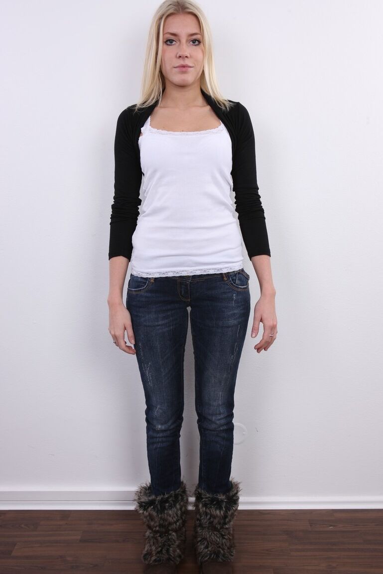 20P Blonde amateur Klara stands fully clothed and then totally naked afore a wall