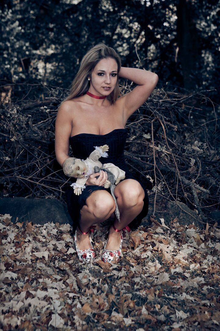 15P Amateur model Nikki Sims holds a creepy doll while squeezing her tits outside