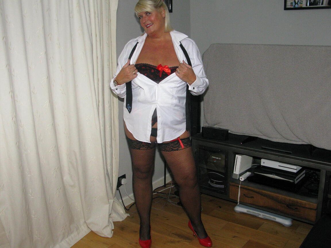 20P Chrissy Uk, une amatrice plus âgée, écarte les lèvres de sa chatte dans un corset et des bas de nylon.