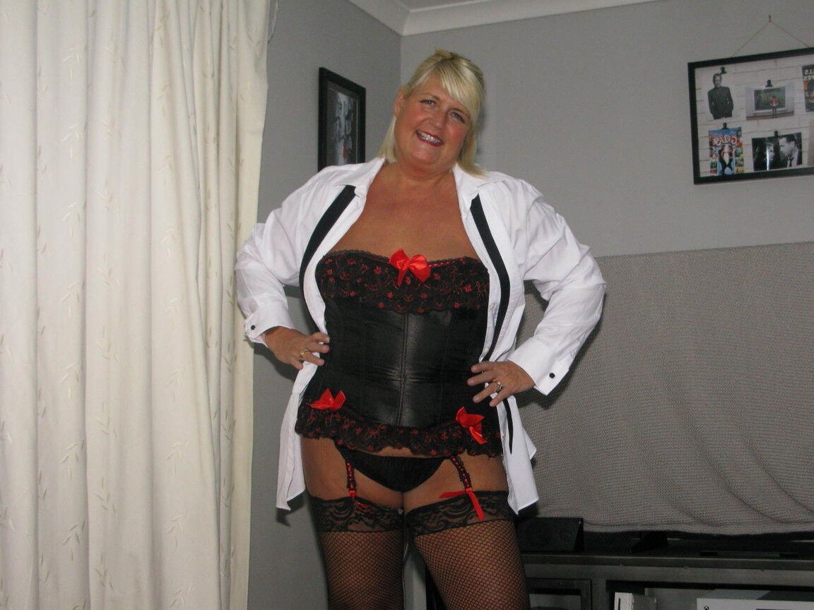 20P Chrissy Uk, une amatrice plus âgée, écarte les lèvres de sa chatte dans un corset et des bas de nylon.