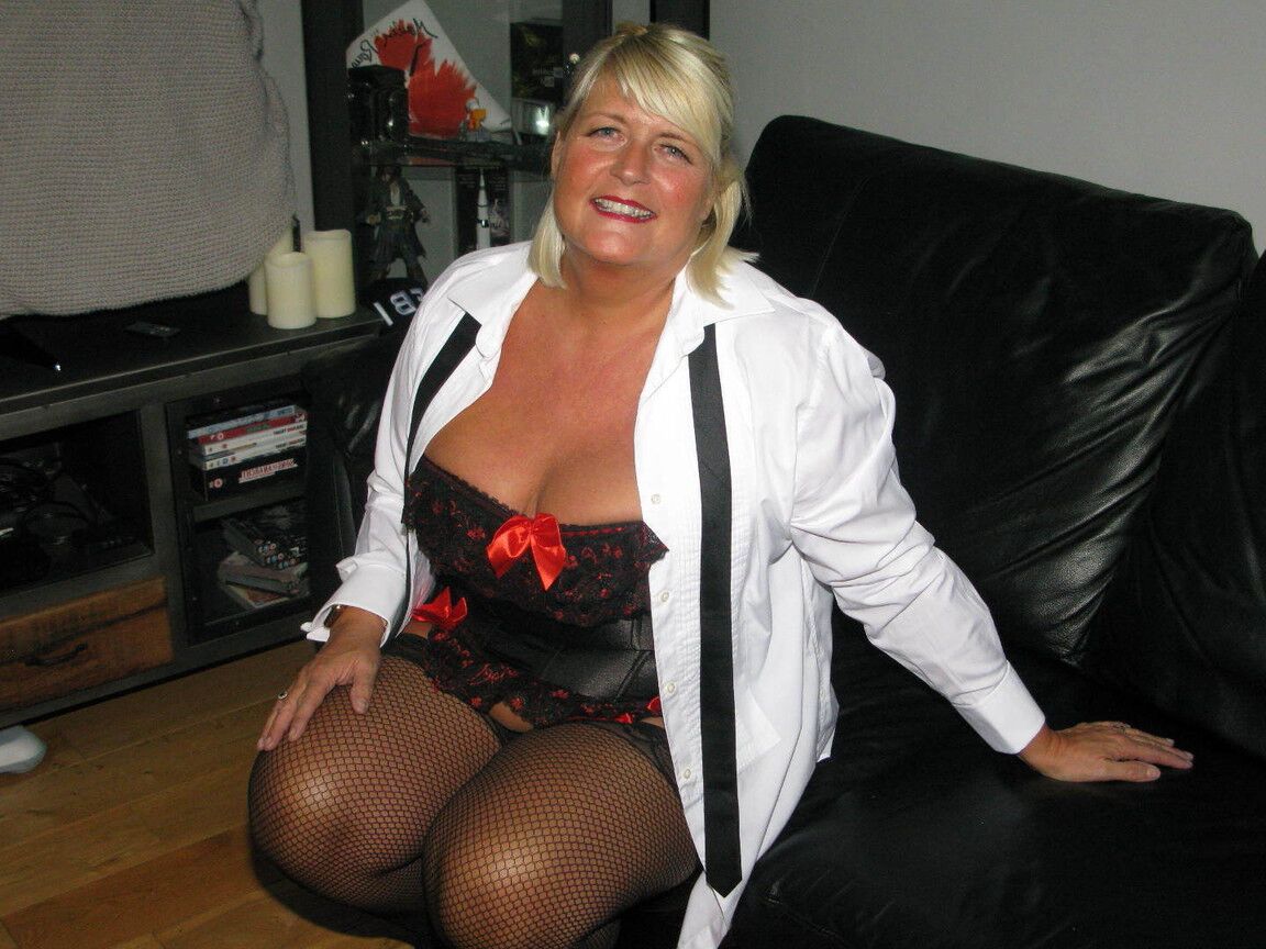 20P Chrissy Uk, une amatrice plus âgée, écarte les lèvres de sa chatte dans un corset et des bas de nylon.