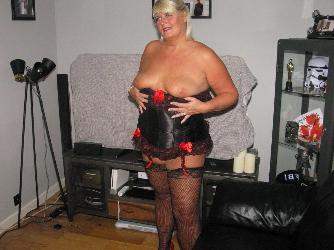 20P Chrissy Uk, une amatrice plus âgée, écarte les lèvres de sa chatte dans un corset et des bas de nylon.