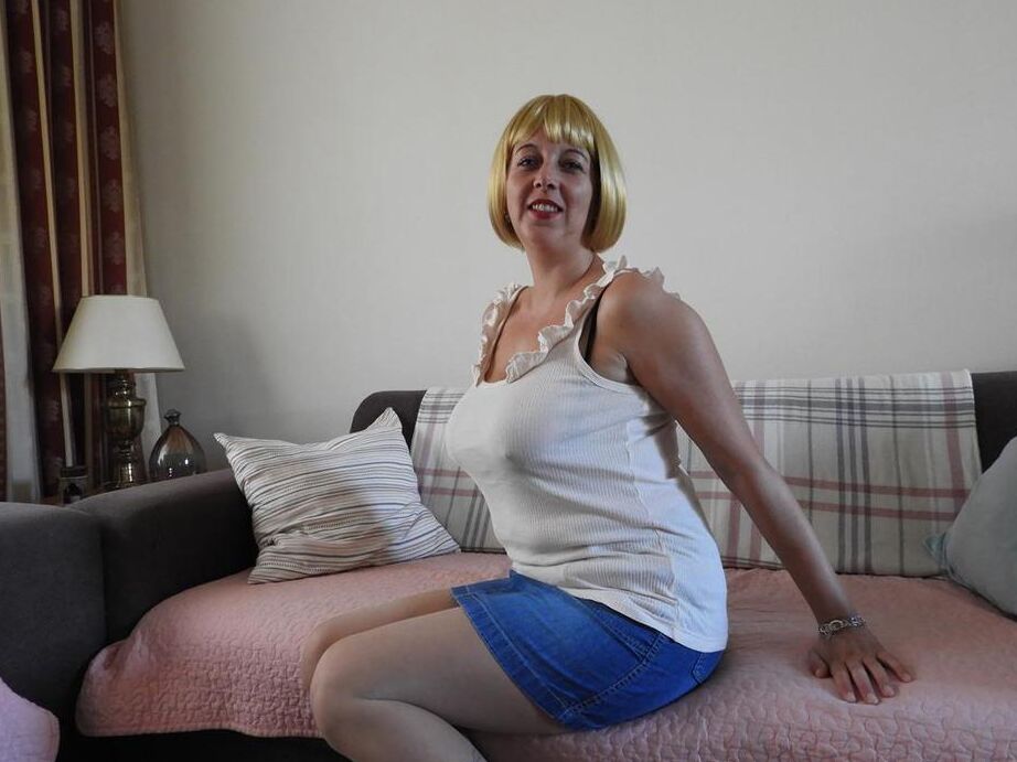 20P La blonde épaisse Kat Lara découvre ses gros seins alors qu'elle se déshabille sur un canapé-lit