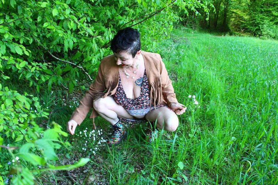 20P Older woman Mary Bitch picks a bunch of flowers while getting naked in a field